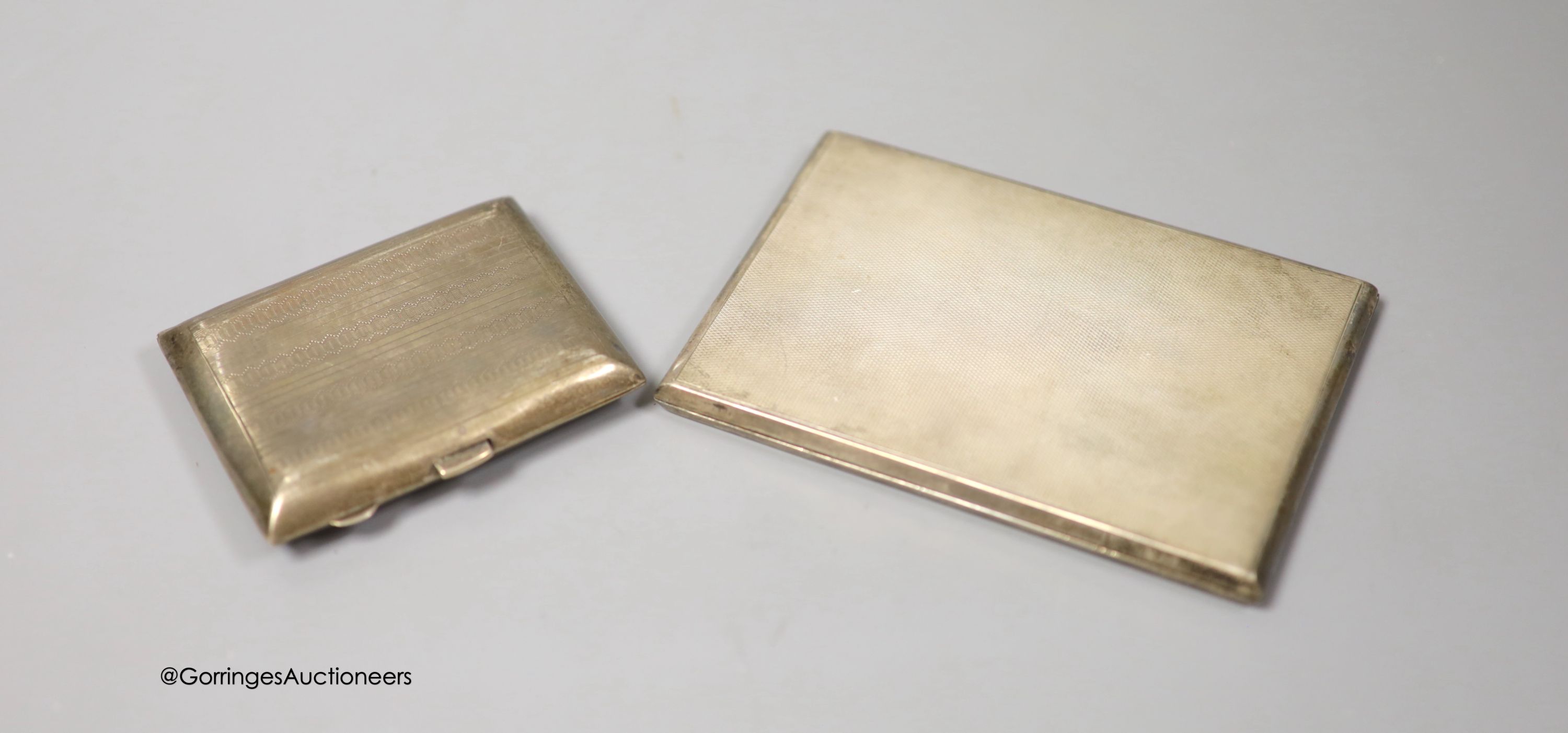 A George VI engine turned silver rectangular cigarette case, Goldsmiths & Silversmiths Co Ltd, London, 1940, 12.3cm and one other smaller silver cigarette case, gross 8.5oz.